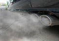 Incomplete combustion creates poisonous carbon monoxide form exhaust pipe of black car, air pollution concept