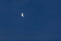 Bright white crescent moon against a cloudless blue sky Royalty Free Stock Photo