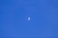Bright white crescent moon against a cloudless blue sky Royalty Free Stock Photo