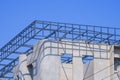 Incomplete precast bare concrete wall with roof beam outline on top of modern office building structure in construction site Royalty Free Stock Photo