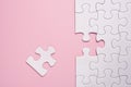 Incomplete white jigsaw puzzle pieces on pink background Royalty Free Stock Photo