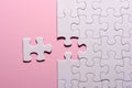 Incomplete white jigsaw puzzle pieces on pink background Royalty Free Stock Photo