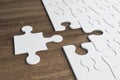 Incomplete white puzzles on wooden table