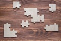 Incomplete wooden puzzles on brown wooden desk, top view, flat lay