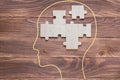 Incomplete wooden puzzles on brown wooden desk, top view, flat lay