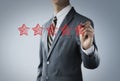 Increase rating, ranking, review, evaluation or classification concept. Businessman is drawing five red stars to increase rating