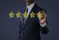 Increase rating, ranking, review, evaluation or classification concept. Businessman is drawing five yellow stars to increase