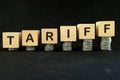 Increase tariff tax concept. Word in wooden blocks with increasing stack of coins. Royalty Free Stock Photo