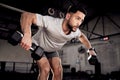 Increased physical activity enhances positive energy. a muscular young man exercising with a dumbbell in a gym. Royalty Free Stock Photo