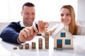 Increased Stack Of Coins Near House Model On The Desk Royalty Free Stock Photo