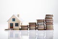 Increasing Coins And House Model On White Desk Royalty Free Stock Photo
