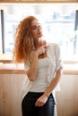 Incredible beautiful redhead young lady posing in cafe. Royalty Free Stock Photo