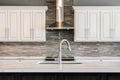 Incredible contemporary kitchen with white cabinets and glass backsplash.