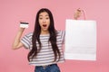 Incredible credit for purchases! Portrait of amazed pretty girl holding bank card and packages, shocked by shopping loan Royalty Free Stock Photo