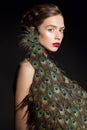 Incredible fashion beauty portrait of attractive girl model with peacock feathers.