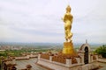 Golden Buddha image in walking posture overlooks the town of Nan, Wat Phra That Khao Noi temple in northern Thailand Royalty Free Stock Photo