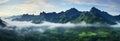 Incredible green mountain vista with fog enveloped midsection and cloud kissed summits