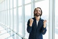 Incredible joy of businessman. Happy manager beside office window with win gesture Royalty Free Stock Photo