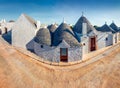 Incredible morning view of strret with trullo trulli - traditional Apulian dry stone hut with a conical roof. Sunny spring city