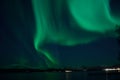 Incredible strong aurora borealis over fjord and snowy mountain Royalty Free Stock Photo