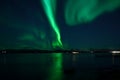 Incredible strong aurora borealis over fjord and snowy mountain Royalty Free Stock Photo