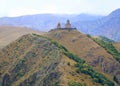 Incredible View of the Gergeti Trinity Church or Tsminda Sameba on the Hilltop with Large Group of Vositors, Georgia Royalty Free Stock Photo