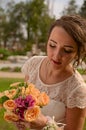 Incredibly beautiful bride with bouquet of roses. Big bumblebee in the bouquet of the bride. Long haired girl in wedding gown