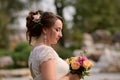 Incredibly beautiful bride with bouquet of roses. Romantic accessory of fiancee. Long haired girl in wedding gown