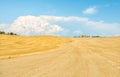 Incredibly beautiful Tuscan landscape with a mowed golden and plowed field, a blue sky with huge white clouds and a small building Royalty Free Stock Photo