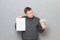 Incredulous man is holding US dollars and white blank paper sheet Royalty Free Stock Photo