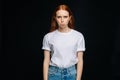 Indecisive young woman wearing T-shirt and denim biting lips apologizing on isolated back background Royalty Free Stock Photo