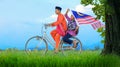 Independence Day concept - happy young local boy riding old bicycle at paddy field holding a Malaysian flag Royalty Free Stock Photo