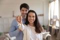 Happy couple buyers of apartment posing with keys in hands Royalty Free Stock Photo