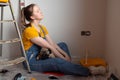 Independent single female sitting on floor and rest with pet dog in her new house during renovation, construction tools Royalty Free Stock Photo