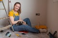 Independent single female sitting on floor and rest with pet dog in her new house during renovation, construction tools Royalty Free Stock Photo