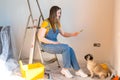 Independent single woman together with a pug dog make repairs in the apartment. Pet always there. renovation apartment Royalty Free Stock Photo