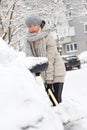 Independent woman shoveling snow in winter.