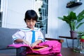 Independent young kindergarten student preparing her own stuff before going to school