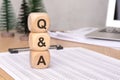 Indepth QA on a Desk Surrounded by Wooden Blocks, Various Paperwork, and Ideas generated