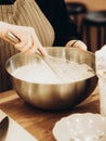 Indeterminate woman mixed batter with whisk in large metal bowl Royalty Free Stock Photo