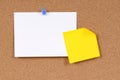 Office index card with post it style yellow sticky note pinned to cork board, copy space