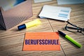 Index cards with legal issues with glasses, pen and bamboo with the german word Berufsschule in english professional school