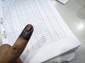 Index finger with indelible ink stain after voting in election with record form background. Royalty Free Stock Photo