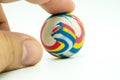 Index or pointing finger touching colorful rubber marble ball is Royalty Free Stock Photo