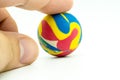 Index or pointing finger touching colorful rubber marble ball is Royalty Free Stock Photo
