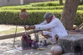 India, Chand Baori step wellHarshat march 28 2023, religious man prays sitting in front of a small temple with swarm of bees