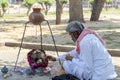 India, Chand Baori step wellHarshat march 28 2023, religious man prays sitting in front of a small temple with swarm of bees