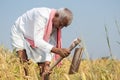 India farmer busy working on agricultural farmland by using hand hoe or garden spade - Concept of rural Indian lifestyle during