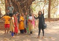 India, GOA, January 18, 2018. A group of Indian girls on a background of a large sacred banyan tree makes a selfie. Selfish on a