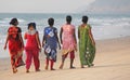 India, GOA, January 22, 2018. A group of Indian women in bright and colorful saris goes along the seashore or the beach. Indian